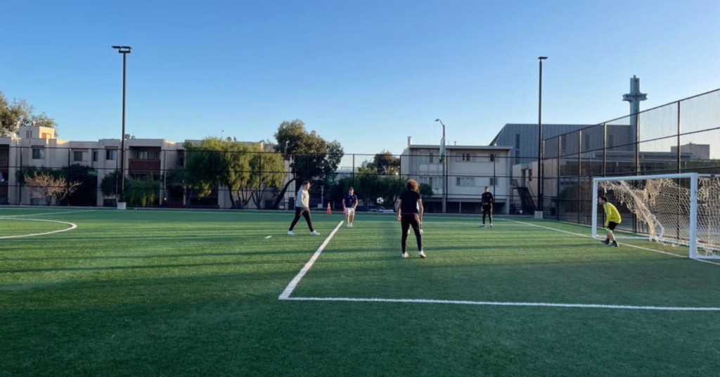 アメリカ留学中に人工芝のグラウンドでサッカーをしている学生たち